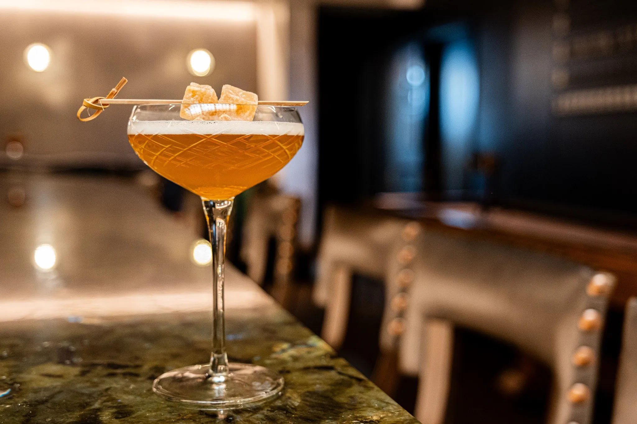 Craft cocktail at The Bar Car in The Union Station Nashville Yards featuring a classic coupe glass with citrus garnish in an elegant historic setting